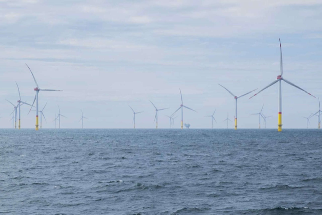 曇り空の下、海に設置された風力発電機の美しい景色。